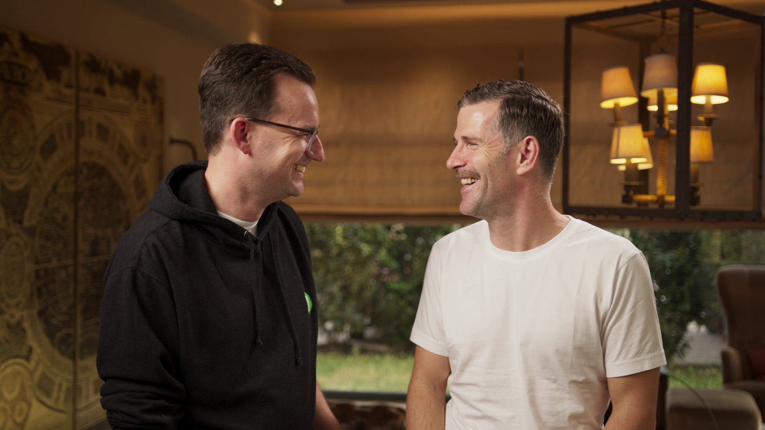 Zwei CEOs von Natuvion stehen sich gegenüber und lachen sich an.